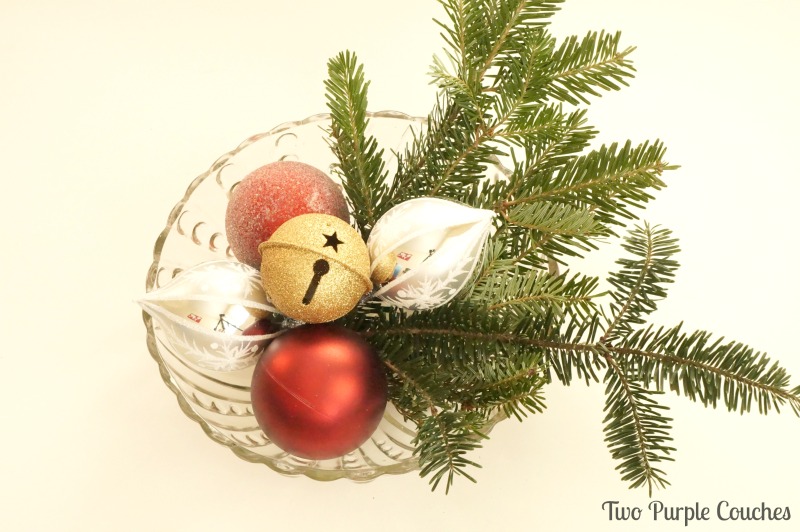 Layer a bowl with greenery and ornaments to create a simple table centerpiece. via www.twopurplecouches.com