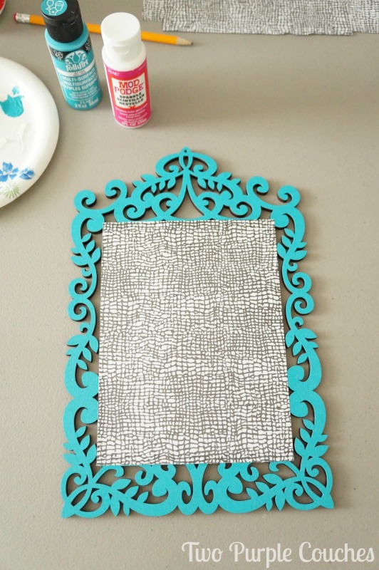 Mod Podge scrapbook paper to a wood surface to create a simple DIY photo holder.  via www.twopurplecouches.com