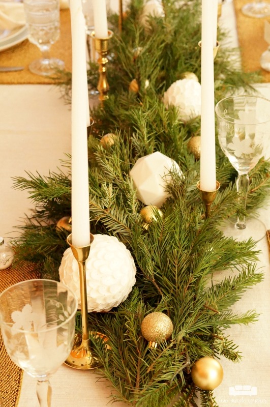 Beautiful holiday table idea! Use fresh, natural greenery and gold or brass candlesticks to create this simple yet elegant DIY evergreen Christmas tablescape. 