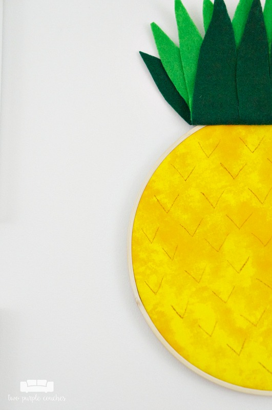 Learn how easy it is to make your own pineapple embroidery hoop art! Transform a simple hoop into trendy pineapple art for your home using fabric & felt!