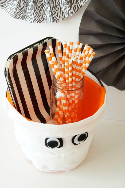 Cute idea for a Halloween party - organize plates, napkins, straws, etc into these cute DIY Mummy Treat Buckets!