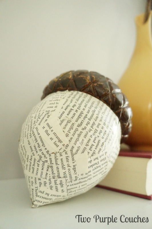 Add interest to a plain plastic acorn using 1" strips of book pages and Mod Podge. via www.twopurplecouches.com #fall #falldecor #mantels #homedecor #modpodge