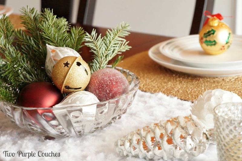 Create a beautiful centerpiece for your holiday table using simple items, like greenery and ornaments, for a festive touch! via www.twopurplecouches.com