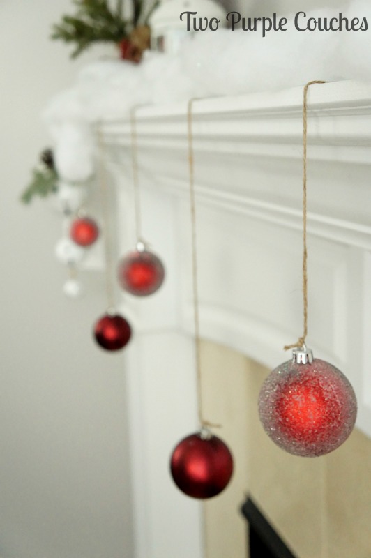 Love this easy decorating idea - hang ornaments from the mantel for an extra pop of color and shimmer!
