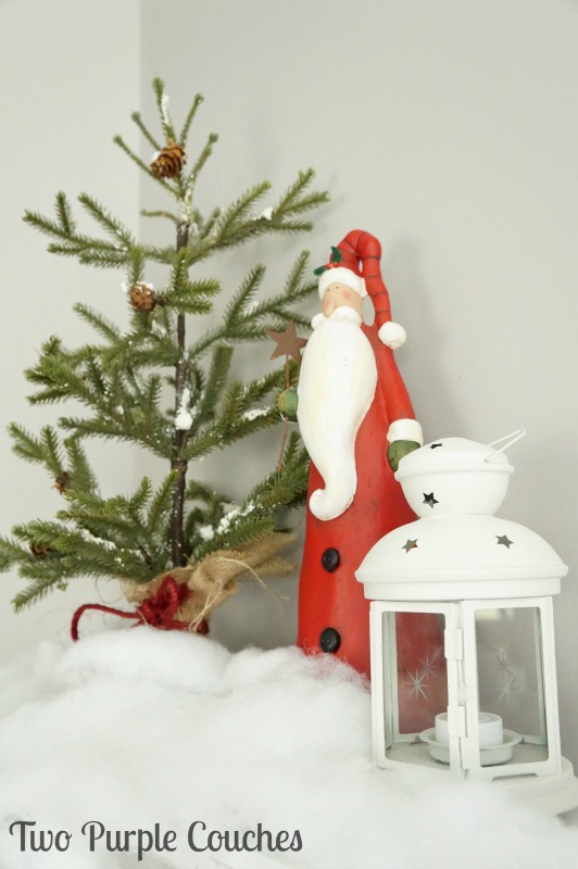 Pair a rustic Santa with a faux tree and lantern for a pretty holiday vignette.