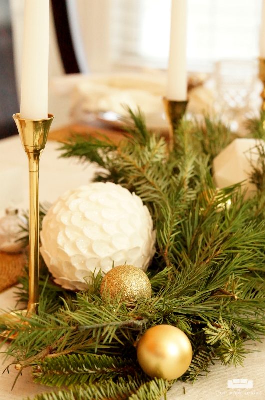 Beautiful holiday table idea! Use fresh, natural greenery and gold or brass candlesticks to create this simple yet elegant DIY evergreen Christmas tablescape.