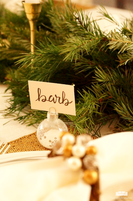 Beautiful holiday table idea! Use fresh, natural greenery and gold or brass candlesticks to create this simple yet elegant DIY evergreen Christmas tablescape. 