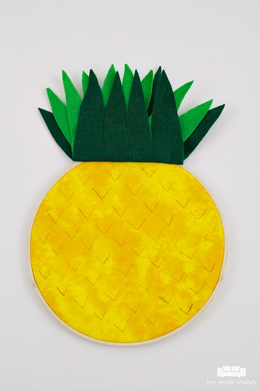 Learn how easy it is to make your own pineapple embroidery hoop art! Transform a simple hoop into trendy pineapple art for your home using fabric & felt!