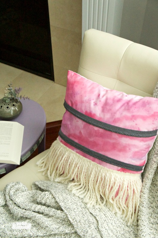 Add a splash of bohemian style to your home or dorm with this easy painted boho pillow with yarn fringe.