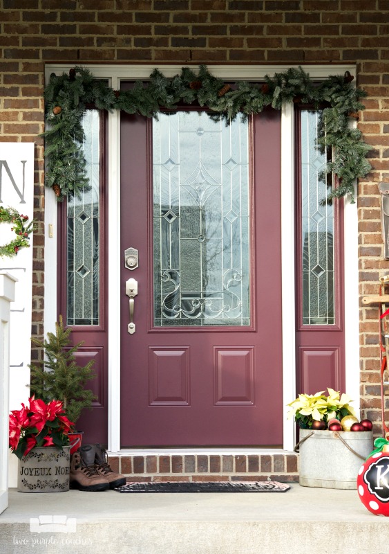 Create a festive holiday porch with these simple decorating ideas! All you need is some Garland, ornaments, evergreen and an easy DIY sign!