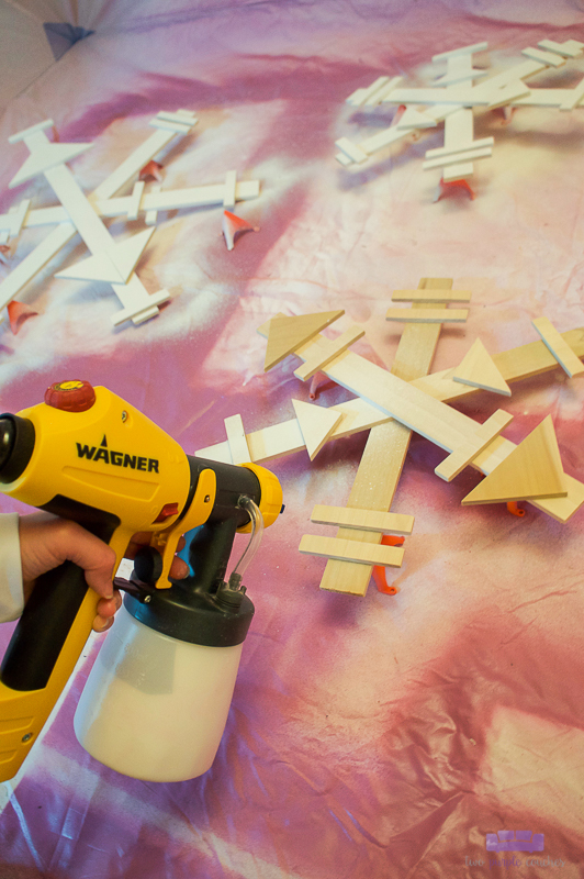 spray painting wooden snowflakes